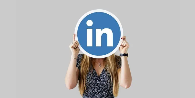 woman hiding her face behind a LinkedIn logo